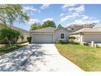 Charming single-story home with a well-maintained lawn and a two-car garage at 2076 Whispering Trails Blvd, Winter Haven, FL 33884