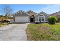 Charming single-story home featuring a well-manicured lawn and attached two car garage at 112 Thorne Meadow Pass, Davenport, FL 33897