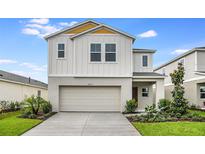 Two-story home with two-car garage, well-manicured landscaping, and bright exterior paint at 4059 Gardenia Ave, Lake Hamilton, FL 33851