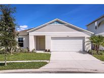 Charming single-story home with a well-manicured lawn and a two-car garage on a sunny day at 1542 Sage Ave, Haines City, FL 33844