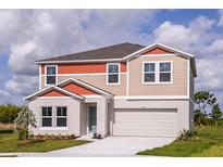 Charming two-story home featuring colorful trim, a two-car garage, and a well-manicured lawn under a sunny sky at 1554 Sage Ave, Haines City, FL 33844