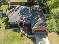Aerial view of a single Gathering home with a fenced yard and large mature trees shading the roof at 5416 Oxford Manor Cir, Lakeland, FL 33810