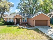 Charming one-story home featuring a well-manicured lawn and attached two-car garage at 5416 Oxford Manor Cir, Lakeland, FL 33810