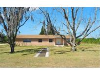 A charming single-story home with a brick facade, a well-maintained lawn, and mature trees at 4305 Hamilton Rd, Lakeland, FL 33811