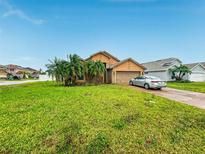 Charming one-story home featuring a well-manicured lawn, attached garage and mature trees in a residential neighborhood at 3035 Buckeye Pointe Dr, Winter Haven, FL 33881