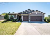 Charming single-story home featuring a three-car garage and well-manicured lawn at 6898 Sw 95Th Cir, Ocala, FL 34481