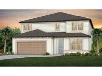 Charming two-story home featuring a symmetrical design, light blue front door, and a two car garage at 1687 Ruby Ln, Lake Alfred, FL 33850