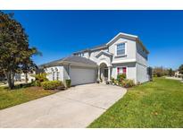 Two-story home with a well-maintained lawn, attached garage, and attractive curb appeal at 622 Copeland Dr, Haines City, FL 33844