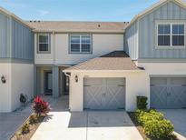 Charming two-story townhome featuring a gray two-car garage, stylish gray and white paint, and a well-maintained lawn at 3926 Grassland Dr, Orlando, FL 32824