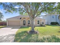 Charming single-story home featuring an attached two-car garage and a well-maintained lawn at 774 Lobelia Dr, Davenport, FL 33837