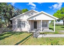 Charming single-story home featuring a cozy front porch, well-maintained lawn, and classic architectural details at 451 Montana Ave, Lakeland, FL 33815