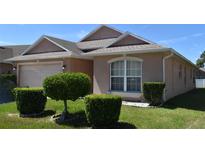 Charming single-story home with a well-manicured lawn and mature landscaping features at 1124 Liberty Hall Dr, Kissimmee, FL 34746