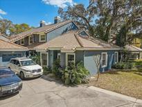 Charming home with blue exterior, tile roof, driveway, and mature landscaping offering curb appeal at 4524 Oak Arbor Cir, Orlando, FL 32802