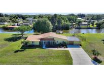 An inviting one-story home with a spacious front yard, attached garage, and scenic waterfront view at 6365 Avocado Dr, Indian Lake Estates, FL 33855