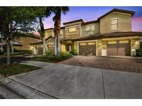 Beautiful townhome exterior with a two-car garage and lush landscaping at dusk at 8983 Azalea Sands Ln # 8983, Davenport, FL 33896