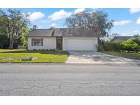 Charming single-Gathering home featuring a two-car garage and a well-maintained front yard at 326 Sand Pine Trl, Winter Haven, FL 33880