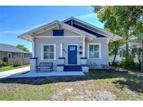 Charming bungalow with blue door, bench seating on the front porch, and mature landscaping at 829 E Lime St, Lakeland, FL 33801