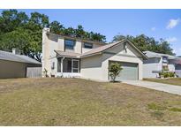 Two-story home featuring a chimney, screened-in porch, and a green garage door, set on a well-maintained lawn at 642 Lake Dexter Cir, Winter Haven, FL 33884