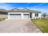 Charming home with a well-manicured lawn, a stone driveway, and a three car garage at 3158 Sailing Pier Ave, Winter Garden, FL 34787
