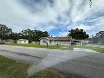 Quaint single-story home with a well-manicured lawn and a convenient carport for parking at 1900 31St Nw St, Winter Haven, FL 33881