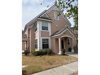 Charming two-story home featuring an arched entrance and freshly landscaped front yard at 3337 Soho St # 103, Orlando, FL 32835