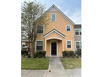 Inviting two-story townhome featuring a charming front porch and well-maintained landscaping at 3301 Soho St # 102, Orlando, FL 32835