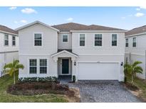 Charming two-story home with a paved driveway, well-kept lawn, and a two-car garage at 1568 Maidstone Ct, Davenport, FL 33896