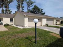 Charming single-story home with a well-manicured lawn and attached two-car garage at 2249 Cypress Cove Dr # E3, Tavares, FL 32778