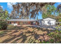 Charming single-story brick home featuring a metal roof and separate two car garage at 7013 Beverly Rd, Lakeland, FL 33813