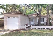 Charming single-story home with a well-maintained lawn, a one-car garage, and mature trees at 645 W Winter Park St, Orlando, FL 32804