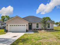Charming single-story home featuring a two-car garage, well-manicured lawn, and lovely front yard landscaping at 917 Shawna Shrs, Haines City, FL 33844