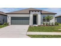 Charming one-story home with a well-manicured lawn, inviting entrance, and a two-car garage at 8953 Wildlight Trl, Wildwood, FL 34785
