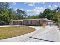 Charming brick home with blue shutters, lush landscaping, and a spacious driveway at 930 29Th Nw St, Winter Haven, FL 33881