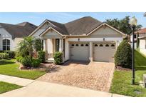 Charming single-story home featuring a two-car garage, brick driveway, and well-maintained landscaping at 2846 Sera Bella Way, Kissimmee, FL 34744