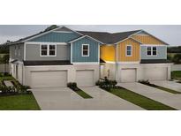 Colorful townhomes showcasing attached garages, neat landscaping, and individual driveways at 3856 King Hill Dr, Haines City, FL 33844