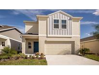 Charming two-story home with neutral siding, a blue front door, and an attached two-car garage at 4075 Gardenia Ave, Lake Hamilton, FL 33851