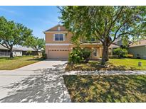 Charming two-story home with a large, well-maintained front yard and a two-car garage at 13525 Mirror Lake Dr, Orlando, FL 32828