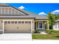 Charming home featuring a two-car garage, well-manicured lawn and a cozy front porch at 3183 Seville St, Lake Alfred, FL 33850