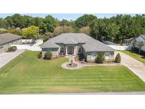 Charming single-story home featuring stone accents, a well-manicured lawn, and a circular driveway with a central fountain at 5144 Riverlake Dr, Bartow, FL 33830