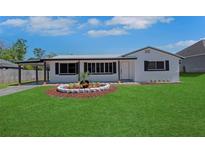 Charming single-story home featuring a well-manicured lawn and decorative front garden at 1475 3Rd Ave, Deland, FL 32724