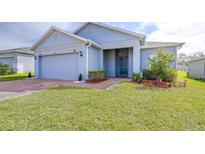 Charming one-story home featuring a well-maintained lawn and brick-paved walkway leading to the front door at 670 Campo Ln, Davenport, FL 33837