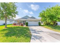Charming single-story home with a well-manicured lawn and a two-car garage, enhancing curb appeal at 30505 Island Club Dr., Deer Island, FL 32778