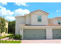 Charming two-story townhome with a red tile roof and a two-car garage at 591 Bay Leaf Dr, Poinciana, FL 34759