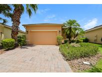 Charming single Gathering home featuring desert landscaping and a brick paver driveway at 1405 Harbor Ridge Dr, Kissimmee, FL 34759
