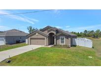 Charming single-Gathering home with a well-manicured lawn, attached garage, and inviting entryway at 329 W Aster Ct, Poinciana, FL 34759