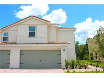 Charming two-story home with neutral siding, attached two-car garage, and beautiful landscaping at 603 Bay Leaf Dr, Poinciana, FL 34759