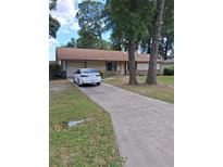 A lovely single-story home with a long driveway and attached garage at 3400 Ne 43Rd Pl, Ocala, FL 34479