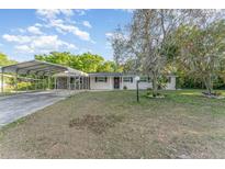 Charming single-story home featuring a covered carport, a well-maintained lawn, and mature trees at 803 Mccranie Rd, Lakeland, FL 33809