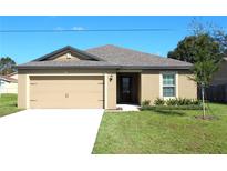Charming single-story home with a well-manicured lawn and attached two-car garage at 58 Herring Ct, Poinciana, FL 34759