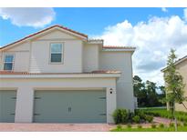 Two-story home with a two-car garage, tile roof, and well-manicured landscaping at 616 Bay Leaf Dr, Poinciana, FL 34759